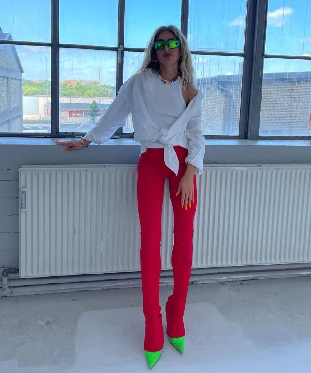 Emili Sindlev - calça legging vermelha, regata branca, camisa e scarpin verde neon - calça legging colorida - Verão - em pé em uma sala - https://stealthelook.com.br