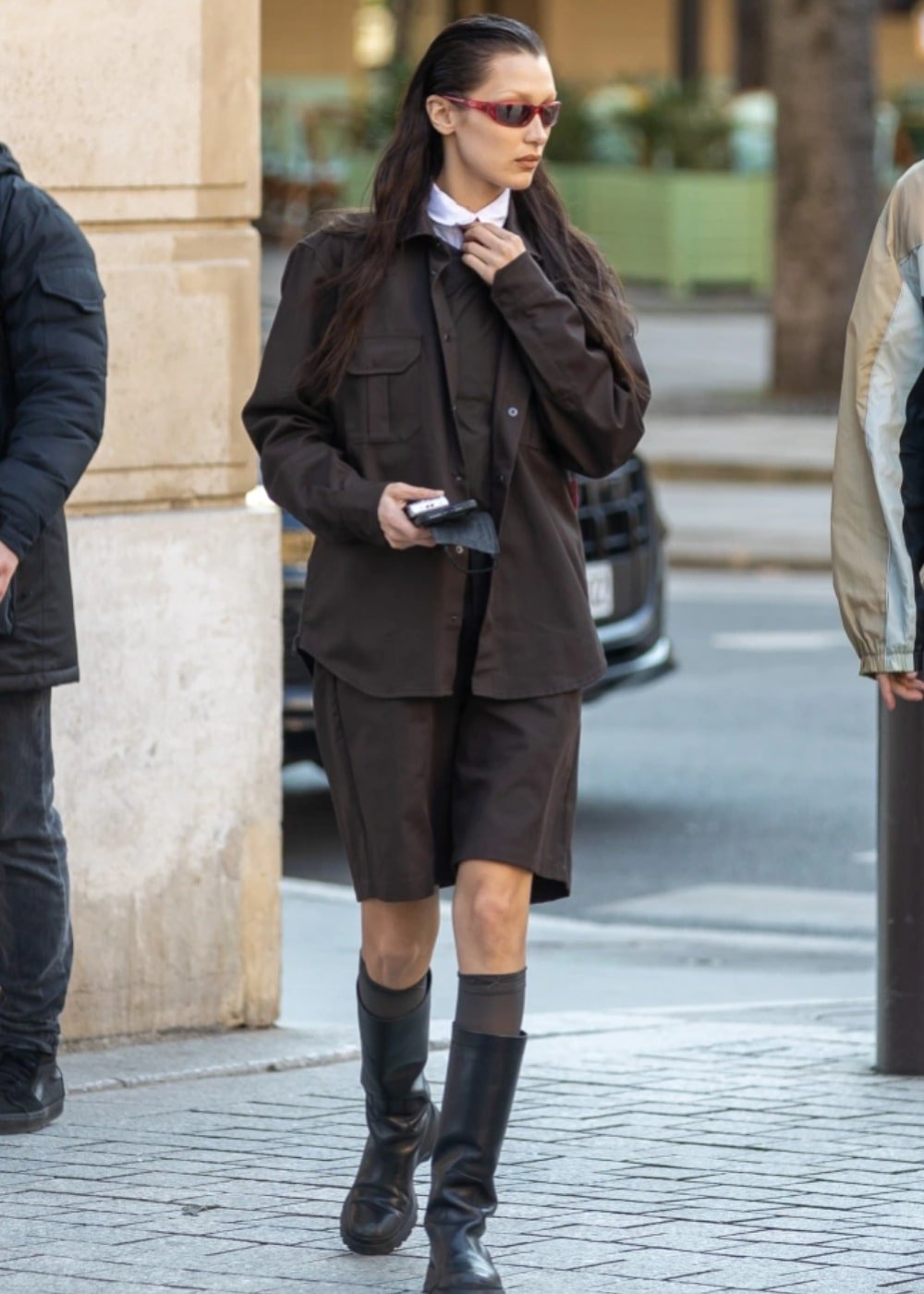 Bella Hadid - bermuda marrom, blazer, óculos vermelho e botas tratoradas de cano longo - Bella Hadid - Outono - andando na rua - https://stealthelook.com.br
