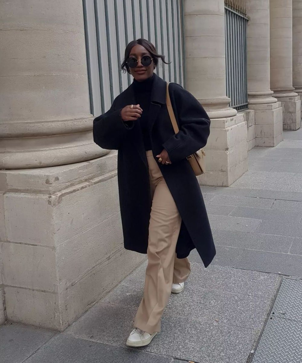 Aïda Badji Sané - calça bege, blusa preta, sobretudo e tênis - casaco sobretudo - Inverno  - andando na rua - https://stealthelook.com.br