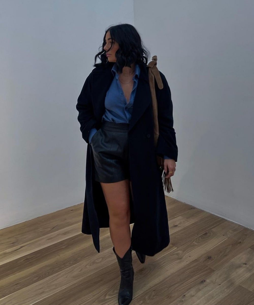 Grace Surguy - shorts, bota western preta, camisa azul e casaco preto - casaco sobretudo - Inverno  - andando em um lugar fechado - https://stealthelook.com.br
