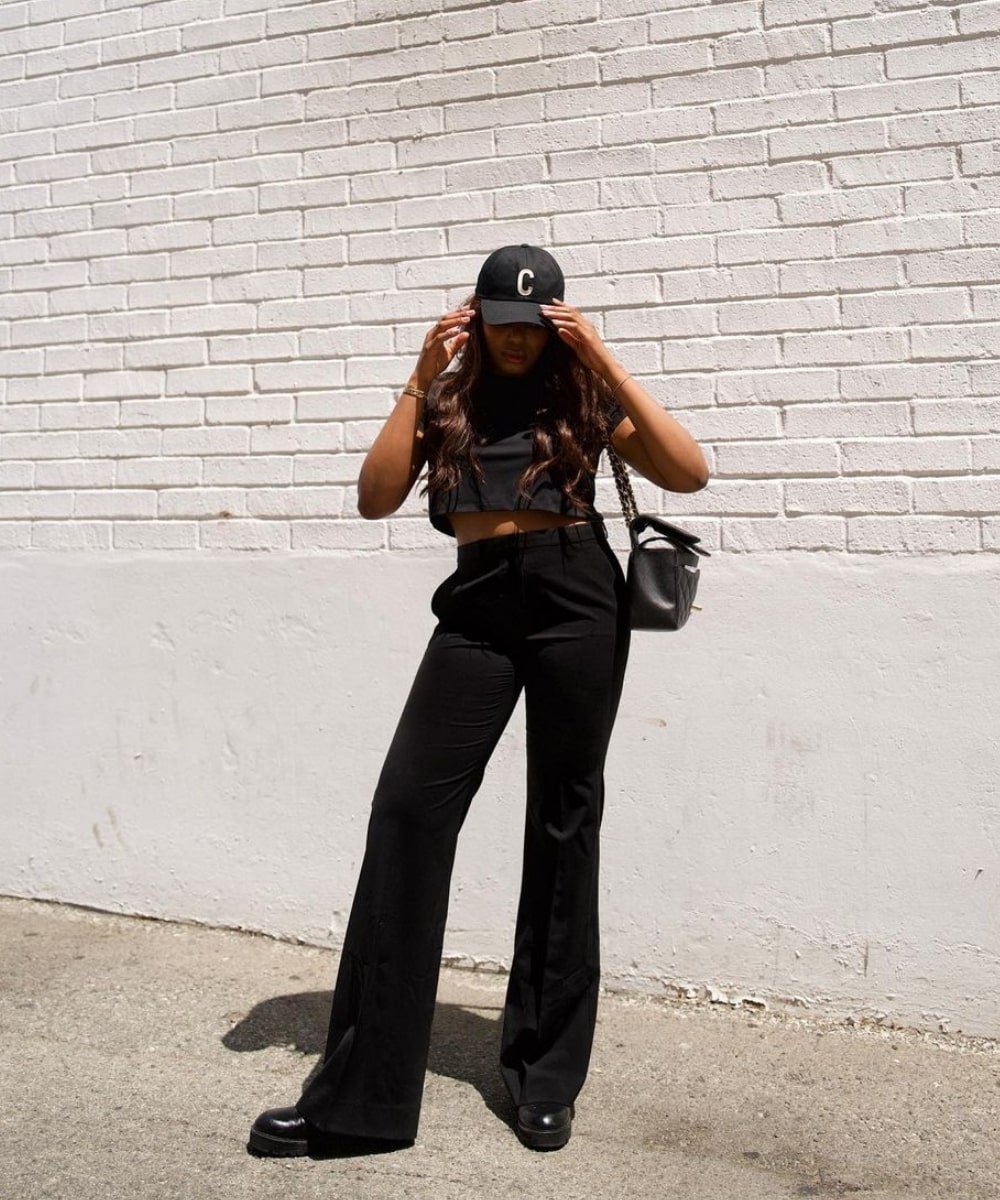 Kaye Bassey - calça preta, cropped e boné - peças de alfaiataria - Verão - em pé na rua - https://stealthelook.com.br