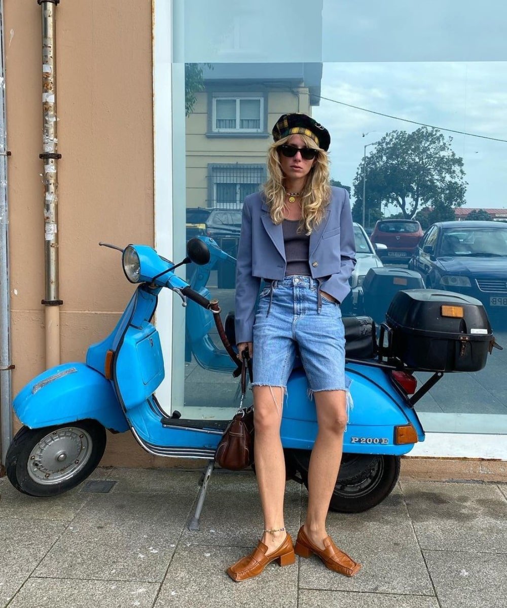 @couturekulten - bermuda jeans, blazer cropped azul e mocassim caramelo - look de verão - Verão - em pé encostada em uma moto azul - https://stealthelook.com.br
