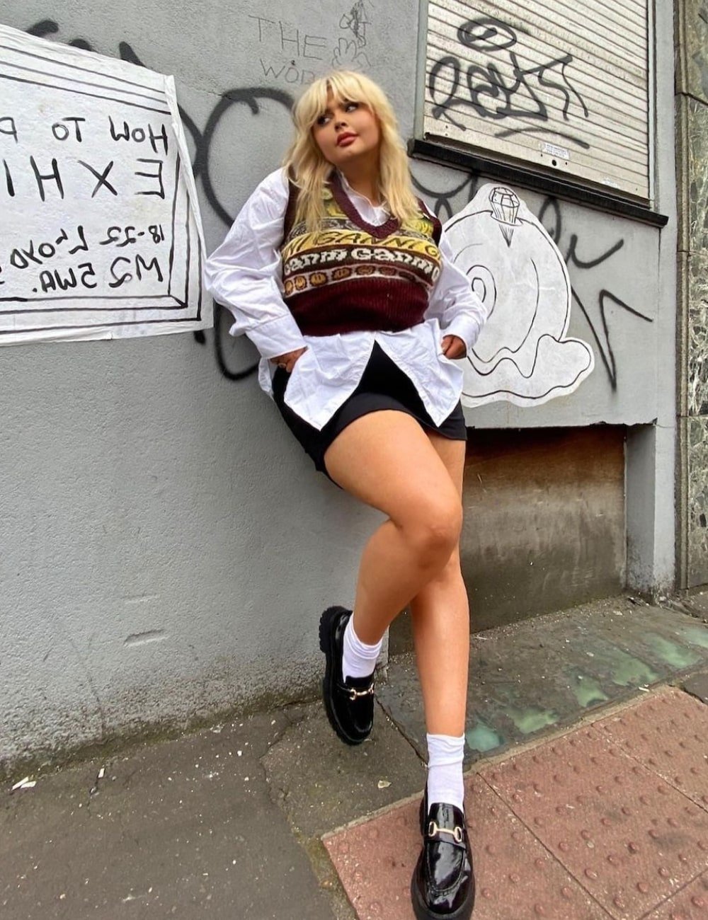 Francesca Perks - biker shorts, camisa branca, colete de tricô e mocassim - looks com mocassim - Verão - em pé na rua - https://stealthelook.com.br