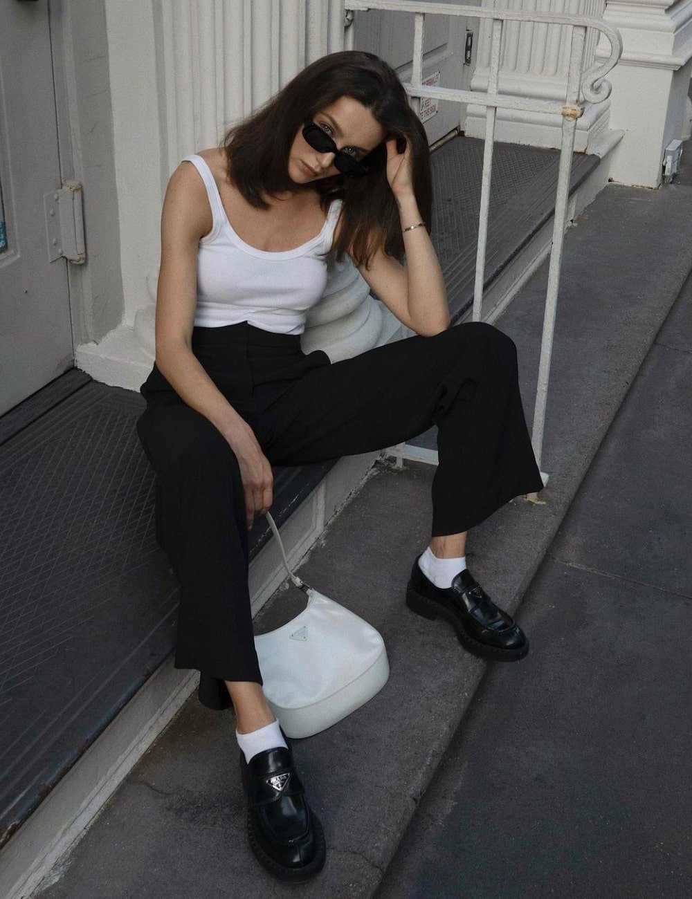Mary Leest - calça de alfaiataria preta, regata branca e mocassim preto - looks com mocassim - Primavera - sentada em uma escada - https://stealthelook.com.br