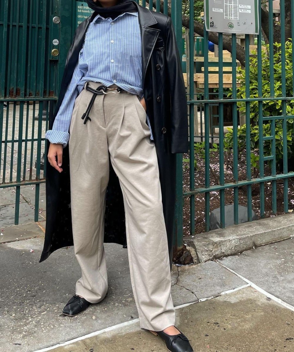 Yusra Siddiqui - calça de alfaiataria, camisa azul social, sapatilha e trench coat - looks com sapatilha - Inverno  - em pé na rua - https://stealthelook.com.br