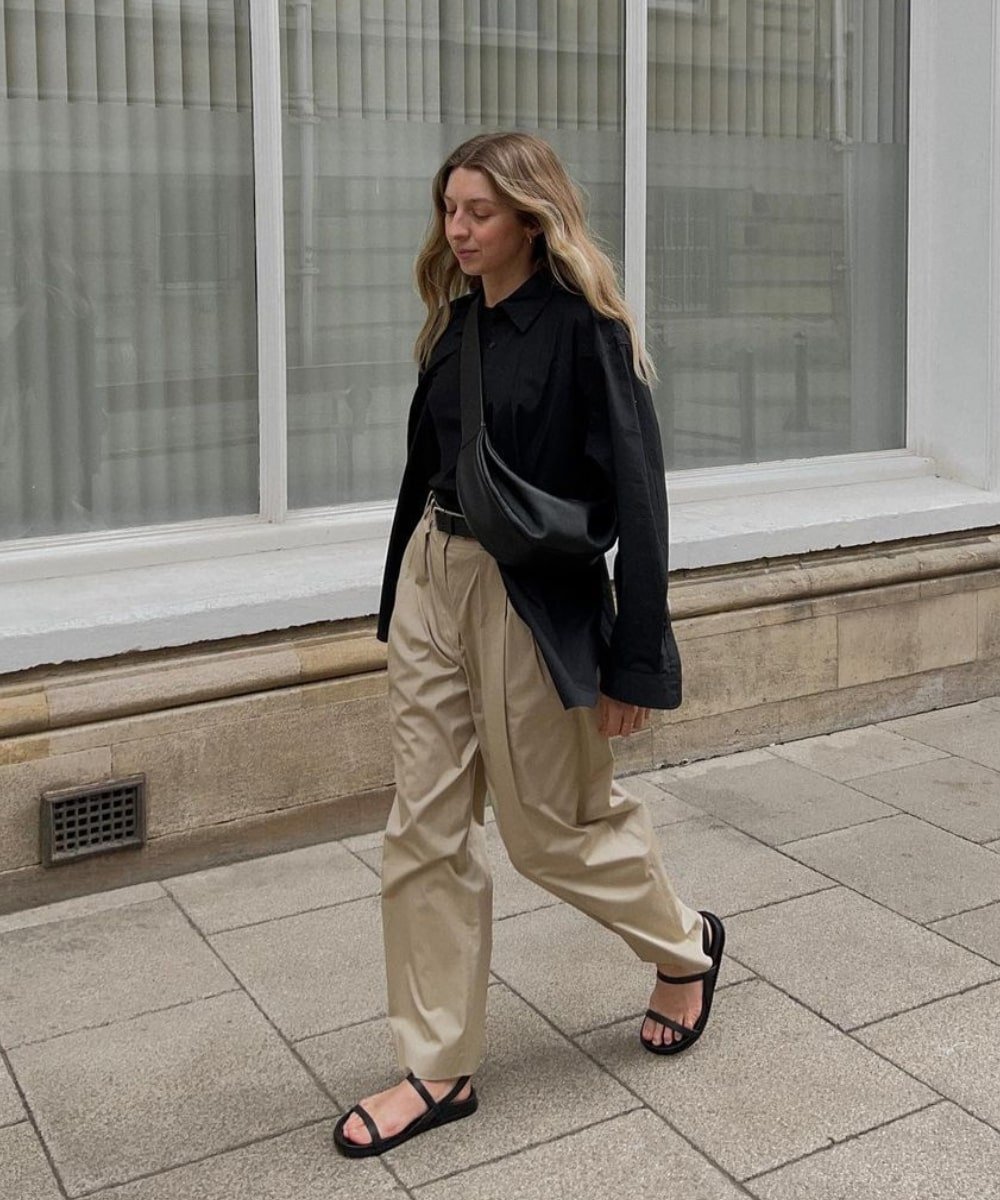 Brittany Bathgate - calça bege, camisa preta oversized e sandálias - Normcore - Outono - andando na rua - https://stealthelook.com.br