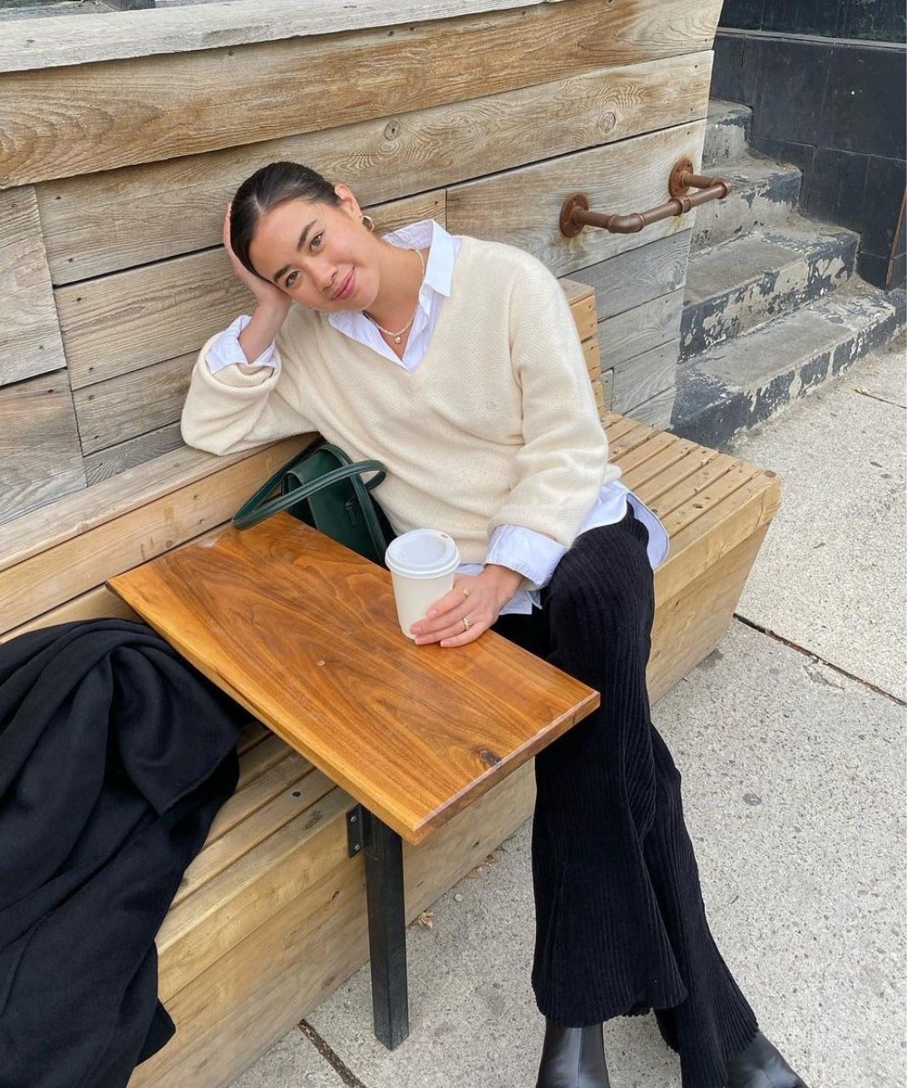 Sasha Mei - calça preta de veludo, camisa branca e tricô - Normcore - Outono - sentada em um café - https://stealthelook.com.br