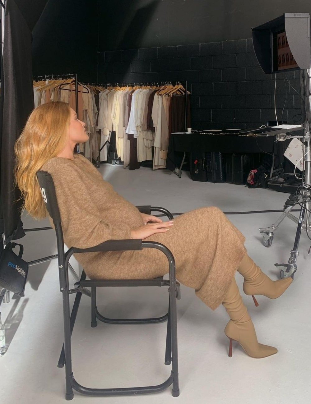 Rosie Huntington-Whiteley - vestido bege longo e botas no mesmo tom - Quiet Luxury - Inverno - sentada em uma cadeira - https://stealthelook.com.br
