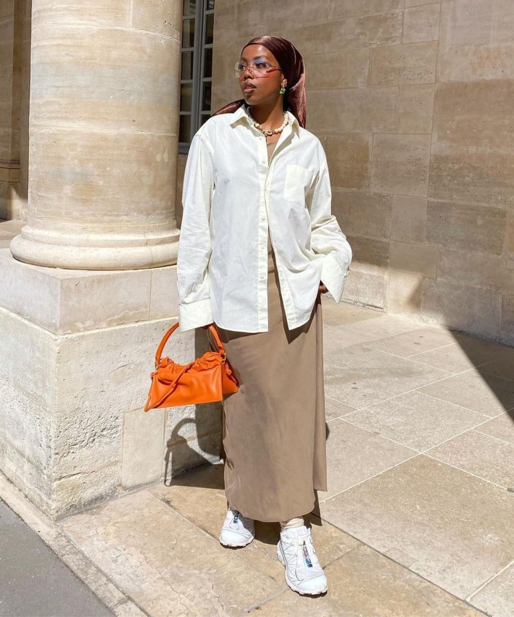 Safya | @blackmaroccan - saia acetinada midi, camisa oversized e bolsa laranja - looks novos - Primavera - em pé na rua - https://stealthelook.com.br
