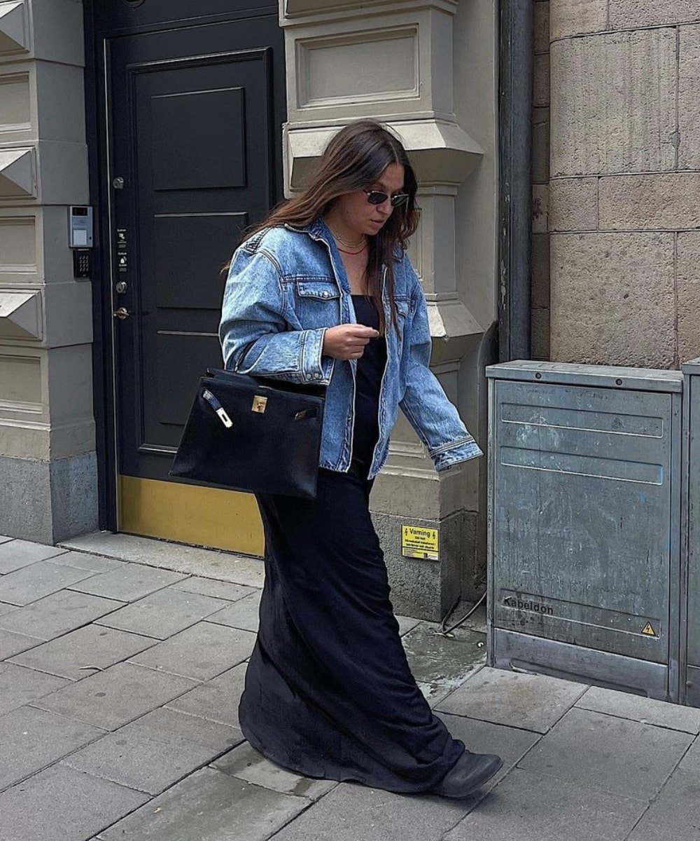 Nadia Kandil - vestido preto, jaqueta jeans e botas - looks novos - Primavera - andando na rua usando óculos de sol - https://stealthelook.com.br