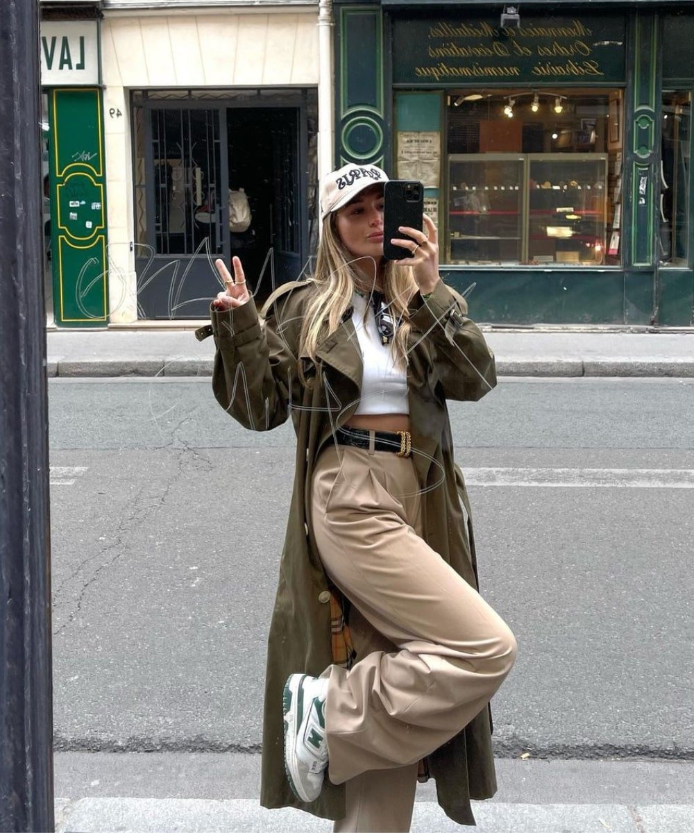 Olivia Faeh - calça bege, regata branca, casaco longo e boné - looks novos - Inverno  - foto na frente de um espelho na rua - https://stealthelook.com.br