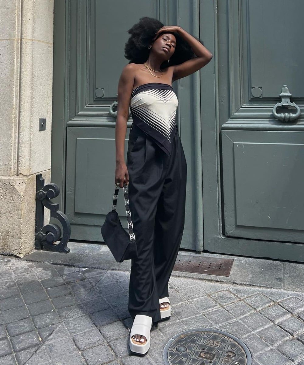 Danielle Jinadu - calça pantalona preta, lenço como blusa e tamancos pretos - looks novos - Verão - em pé na rua - https://stealthelook.com.br