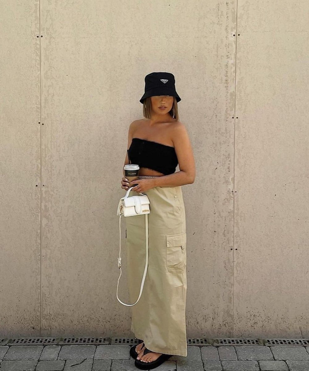 Hannah Whiting - saia longa cargo bege, top preto e bucket hat preto - verão 2023 - Verão - em pé na rua - https://stealthelook.com.br