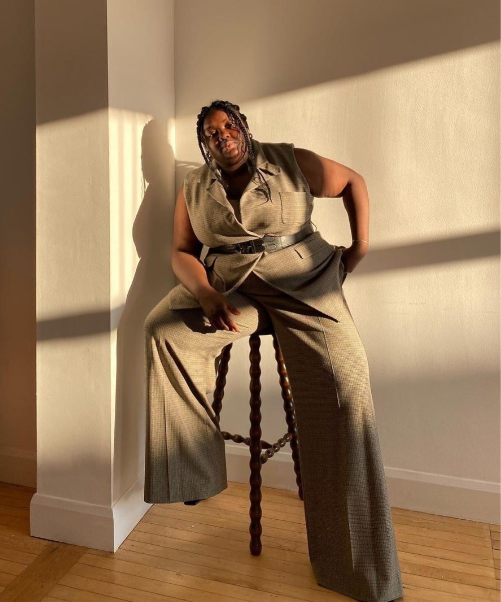Abisola Omole - calça de alfaiataria, colete e cinto por cima do look - como usar cinto - Verão - sentada em um banco - https://stealthelook.com.br