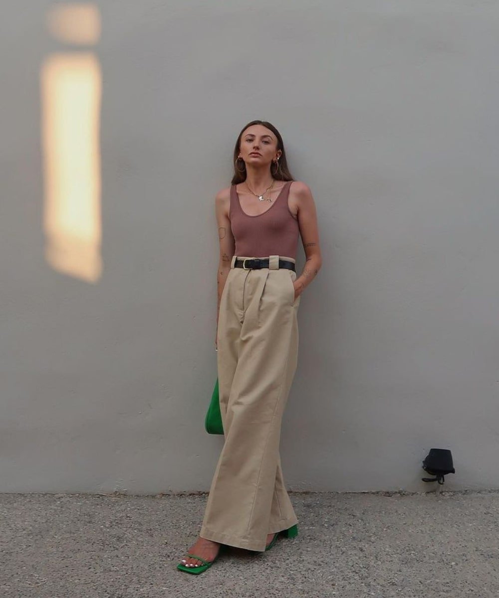 Chloe Hayward - calça de alfaiataria, cinto preto e regata rose - como usar cinto - Verão - em pé na rua - https://stealthelook.com.br
