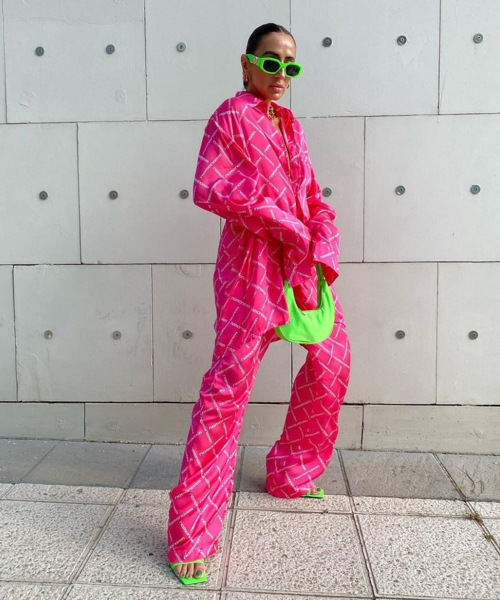 Laura Eguizabal - conjunto acetinado pink, óculos e bolsa verde neon - Barbiecore - Primavera - em pé na rua - https://stealthelook.com.br