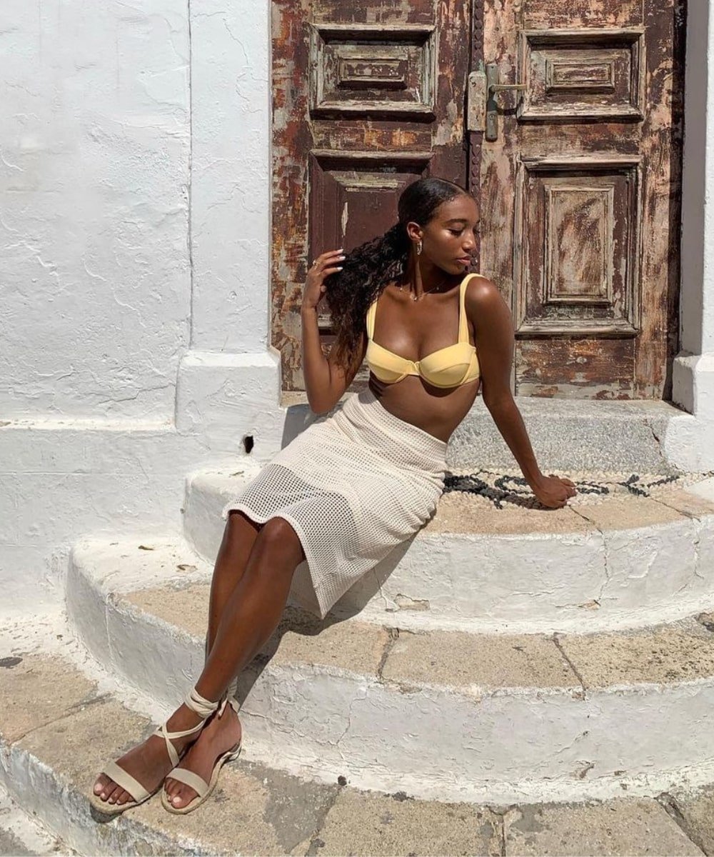 Solène Oj - saia midi, cropped amarelo, rasteirinha - moda verão 2023 - Verão - sentada em uma escada - https://stealthelook.com.br