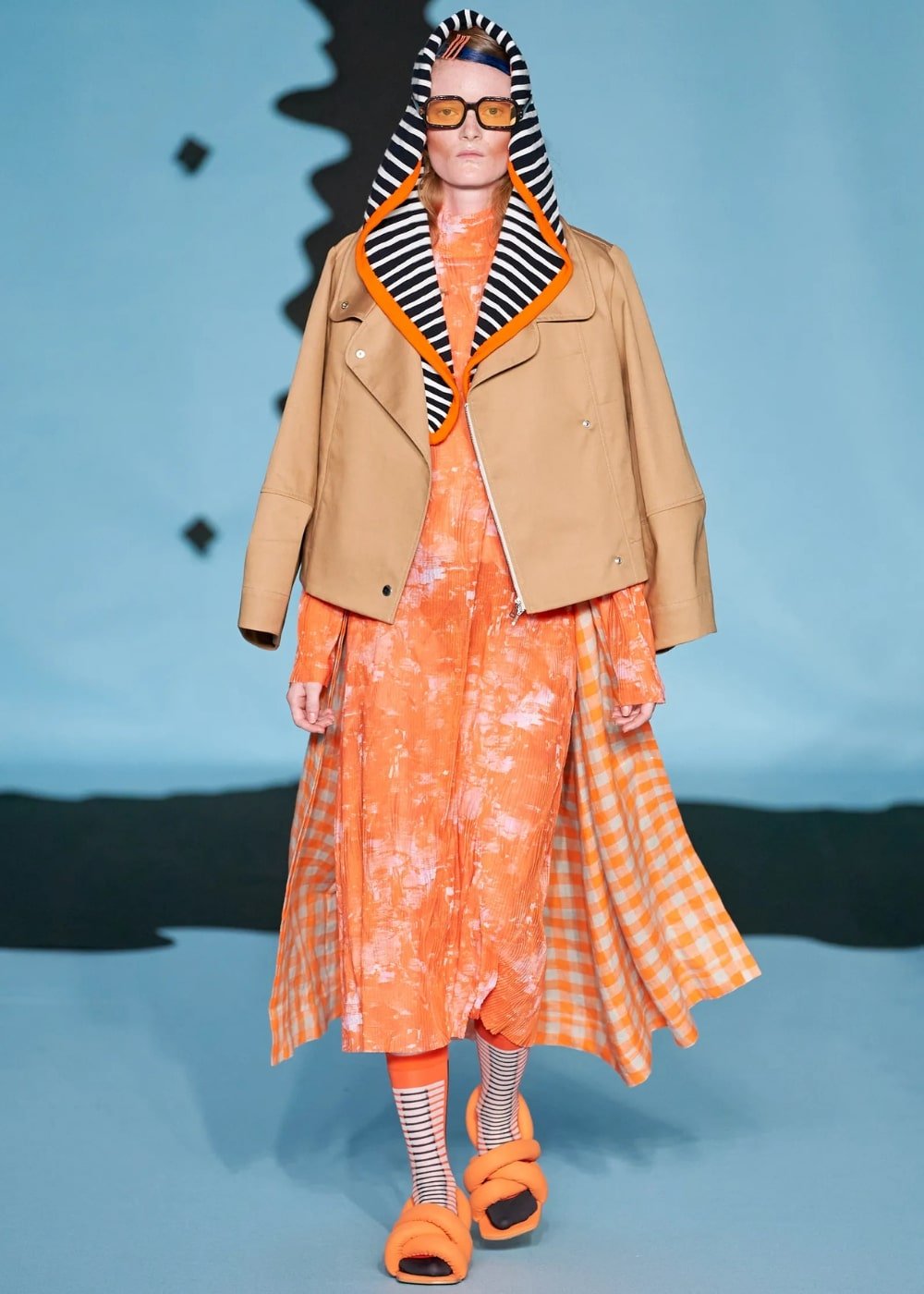 Henrik Vibskov - vestido estampado laranja, com casaco bege e óculos de lentes coloridas - semana de moda de Copenhagen - Primavera - modelo andando pela passarela - https://stealthelook.com.br