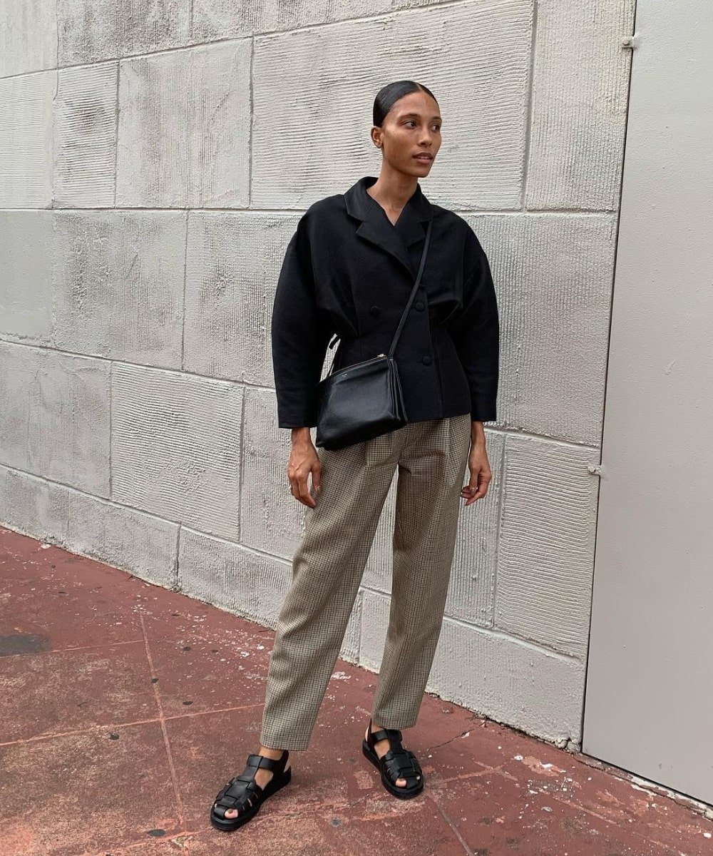 TyLynn Nguyen - calça bege, camisa preta e sandália fisherman - modelos de sapatos - Verão - em pé na rua - https://stealthelook.com.br