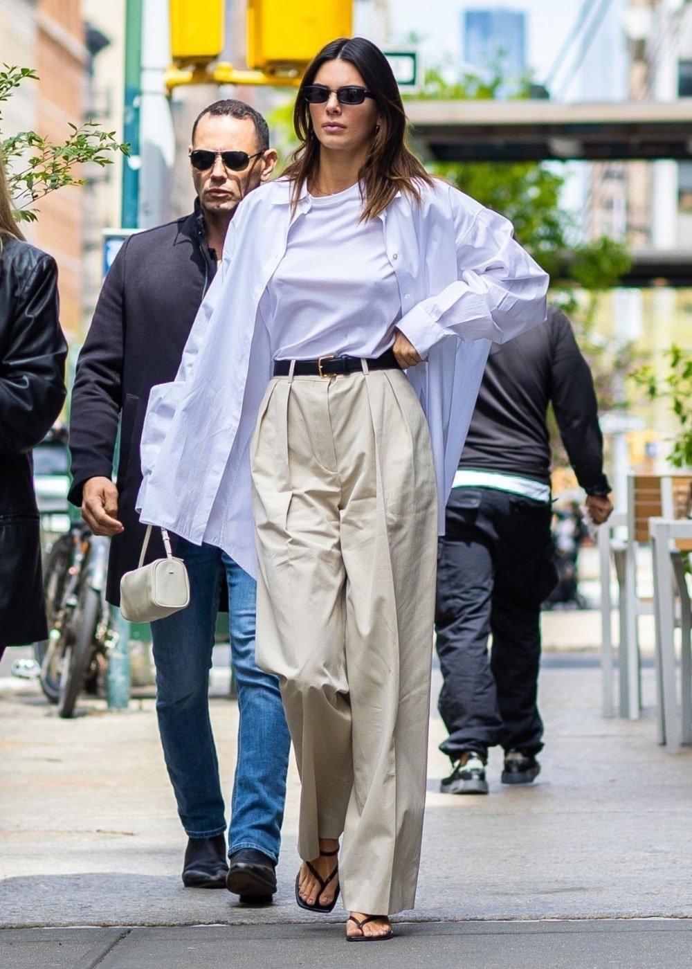 Kendall Jenner - calça de alfaiataria bege, regata branca e camisa oversized - looks básicos - Primavera - andando na rua - https://stealthelook.com.br