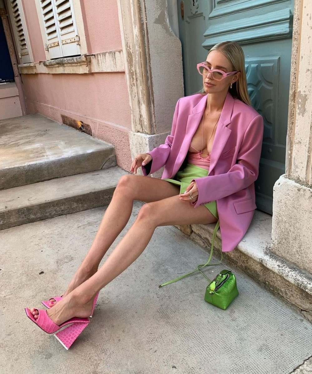 Leonie Hanne - saia verde, top rosa, blazer rosa e tamanco pink - Barbiecore - Verão - sentada na rua - https://stealthelook.com.br