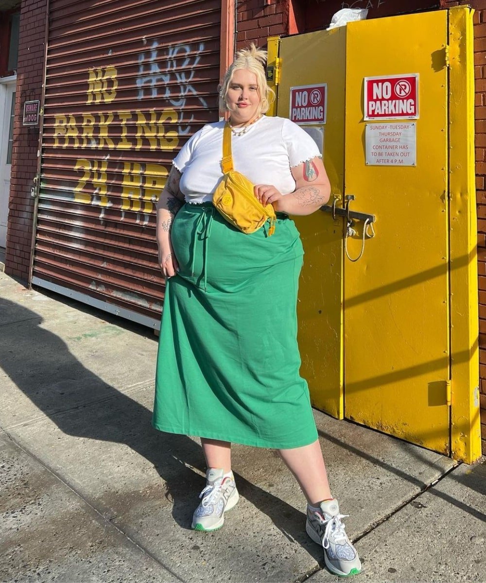 Abby Bible - saia de moletom verde, cropped branco e tênis - saia midi - Verão - em pé na rua usando uma bolsa amarela - https://stealthelook.com.br
