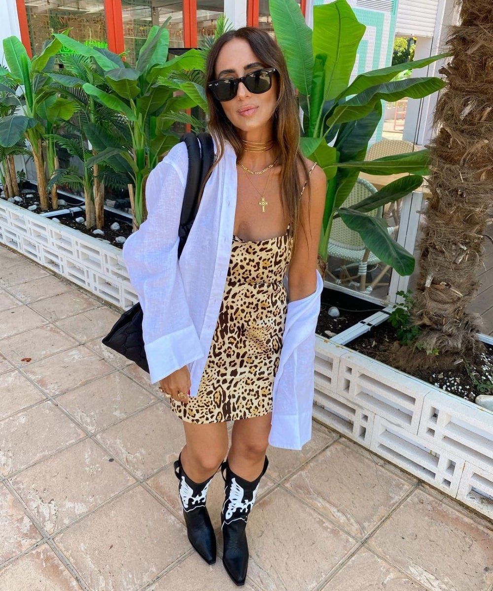 Laura Eguizabal - vestido de animal print, camisa e botas western - looks novos - Verão - em pé na rua usando óculos de sol - https://stealthelook.com.br