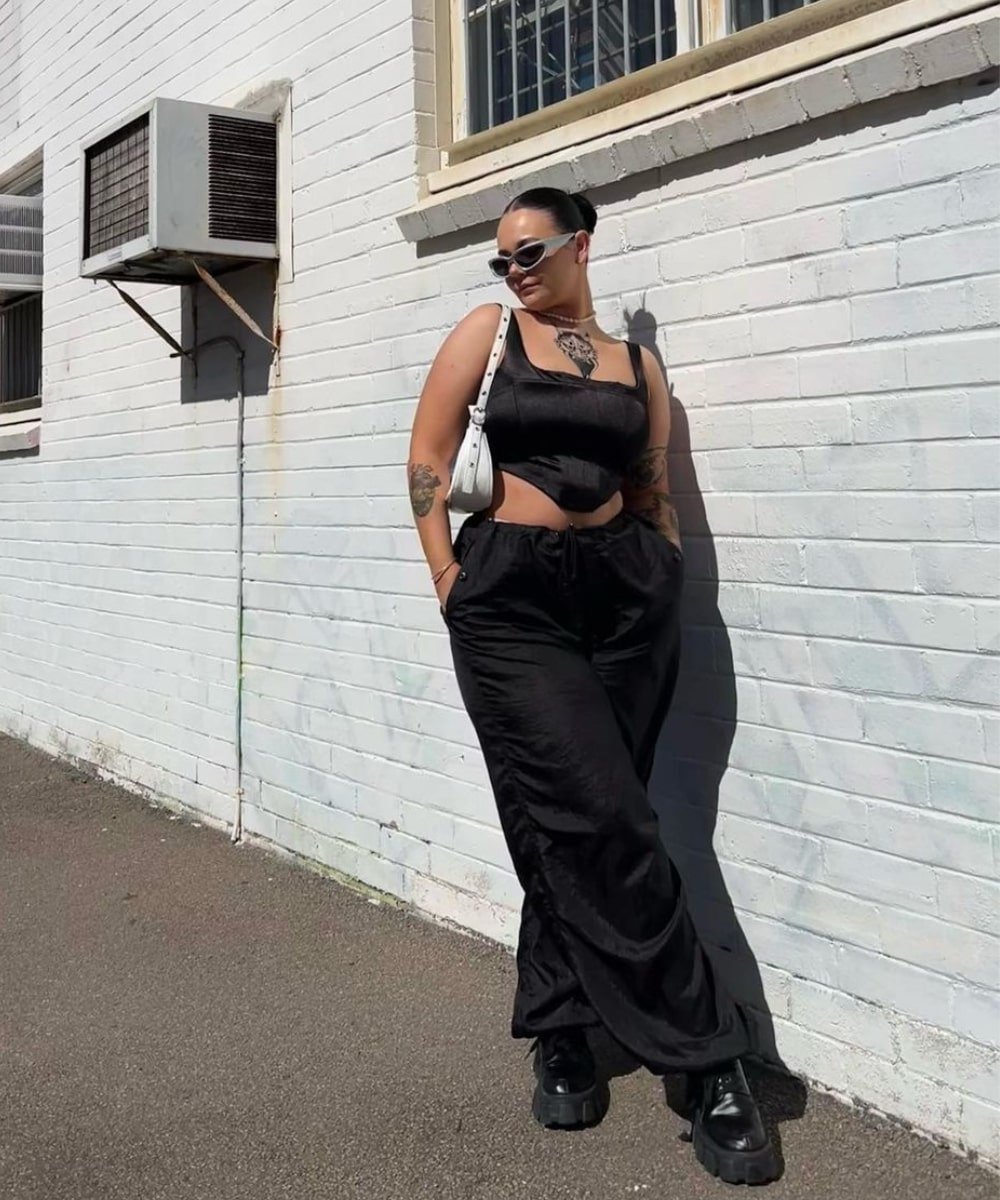 Chelsea Butcher - calça parachute preta, corset preto e bolsa branca - looks novos - Primavera - em pé na rua usando óculos de sol - https://stealthelook.com.br