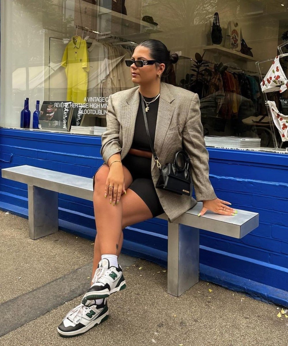 Freya Broni - biker shorts preto, top, blazer e tênis - acessórios de moda - Outono - sentada em um banco usando óculos de sol - https://stealthelook.com.br