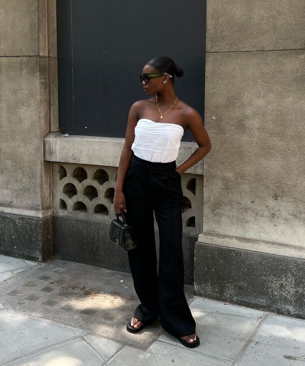 Rabia Cissokho - calça preta, top sem alças e chinelo preto - looks com chinelo - Verão - em pé na rua usando óculos de sol - https://stealthelook.com.br