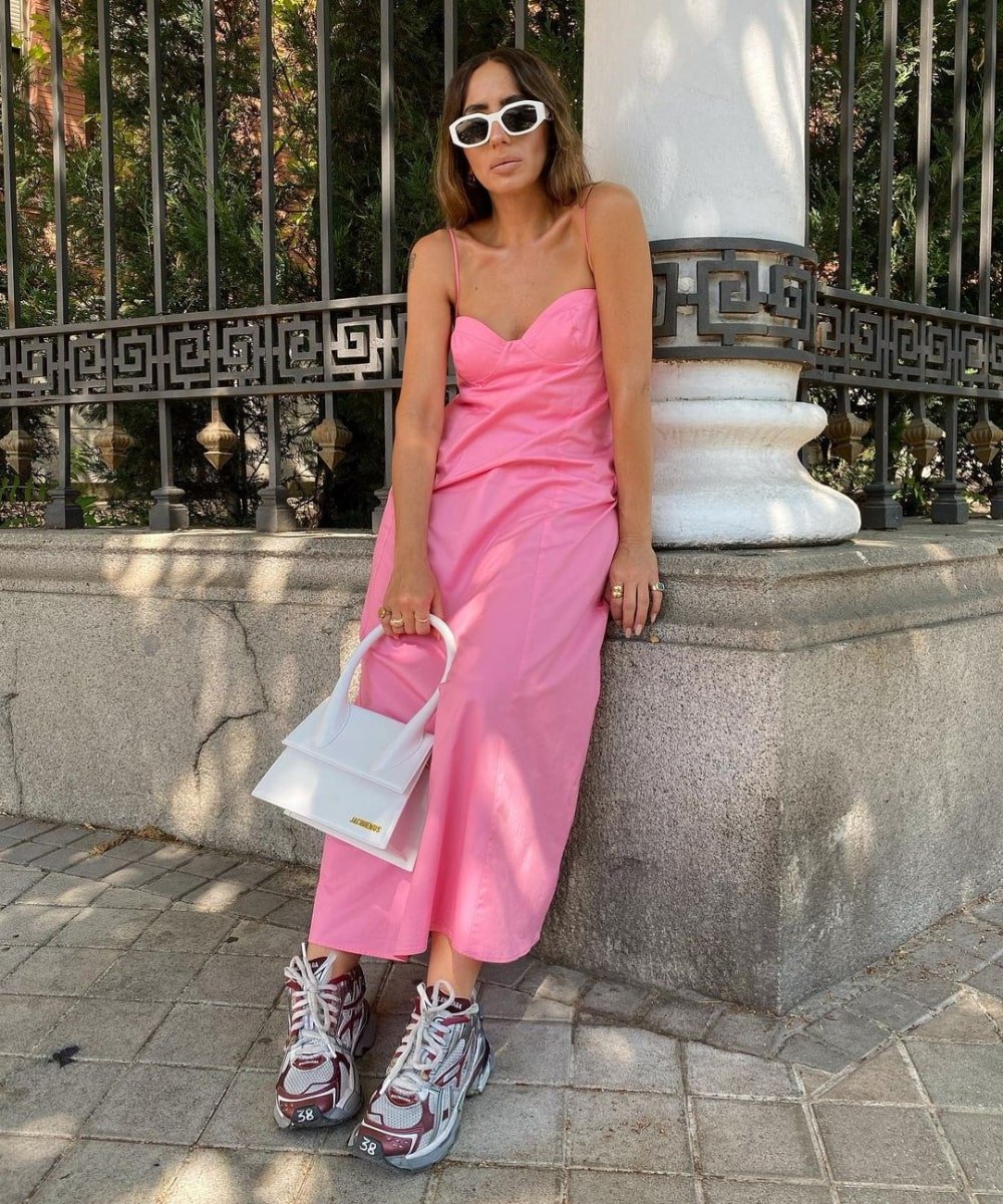 Laura Eguizabal - vestido rosa liso e tênis vermelho - verão 2023 - Verão - em pé na rua usando óculos de sol - https://stealthelook.com.br