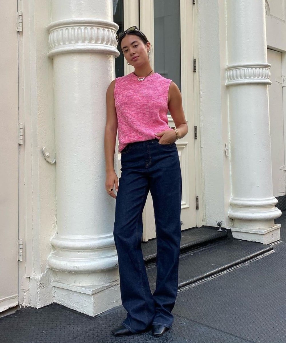 Sasha Mei - calça jeans, botas pretas e colete rosa de tricô - primavera 2023 - Primavera - em pé na rua - https://stealthelook.com.br