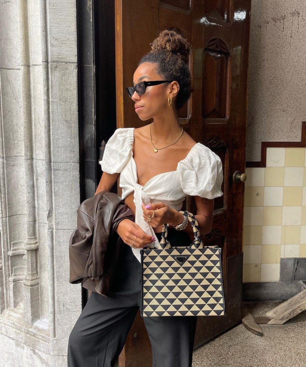 Amaka Hamelijnck - calça preta, cropped branco de manga bufante e óculos - blusa tendência - Verão - em pé na rua usando óculos de sol - https://stealthelook.com.br