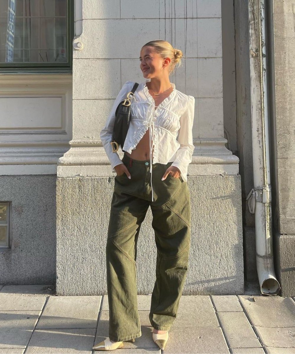 Matilda Djerf - calça verde, bata branca de amarração e tênis - verão 2023 - Verão - em pé na rua - https://stealthelook.com.br