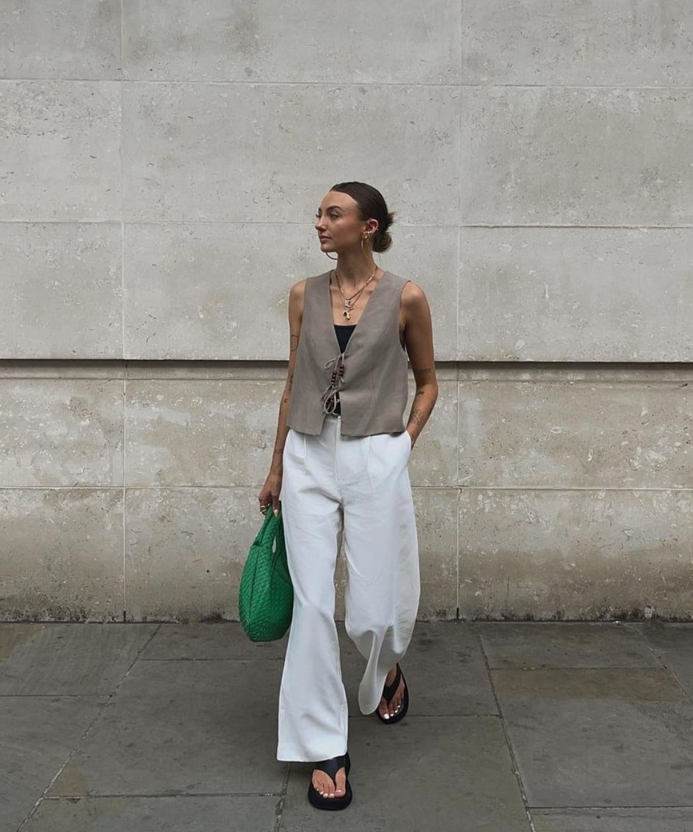 Chloe Hayward - pantalona off white, colete e bolsa verde - tendência de moda - Verão - andando na rua - https://stealthelook.com.br