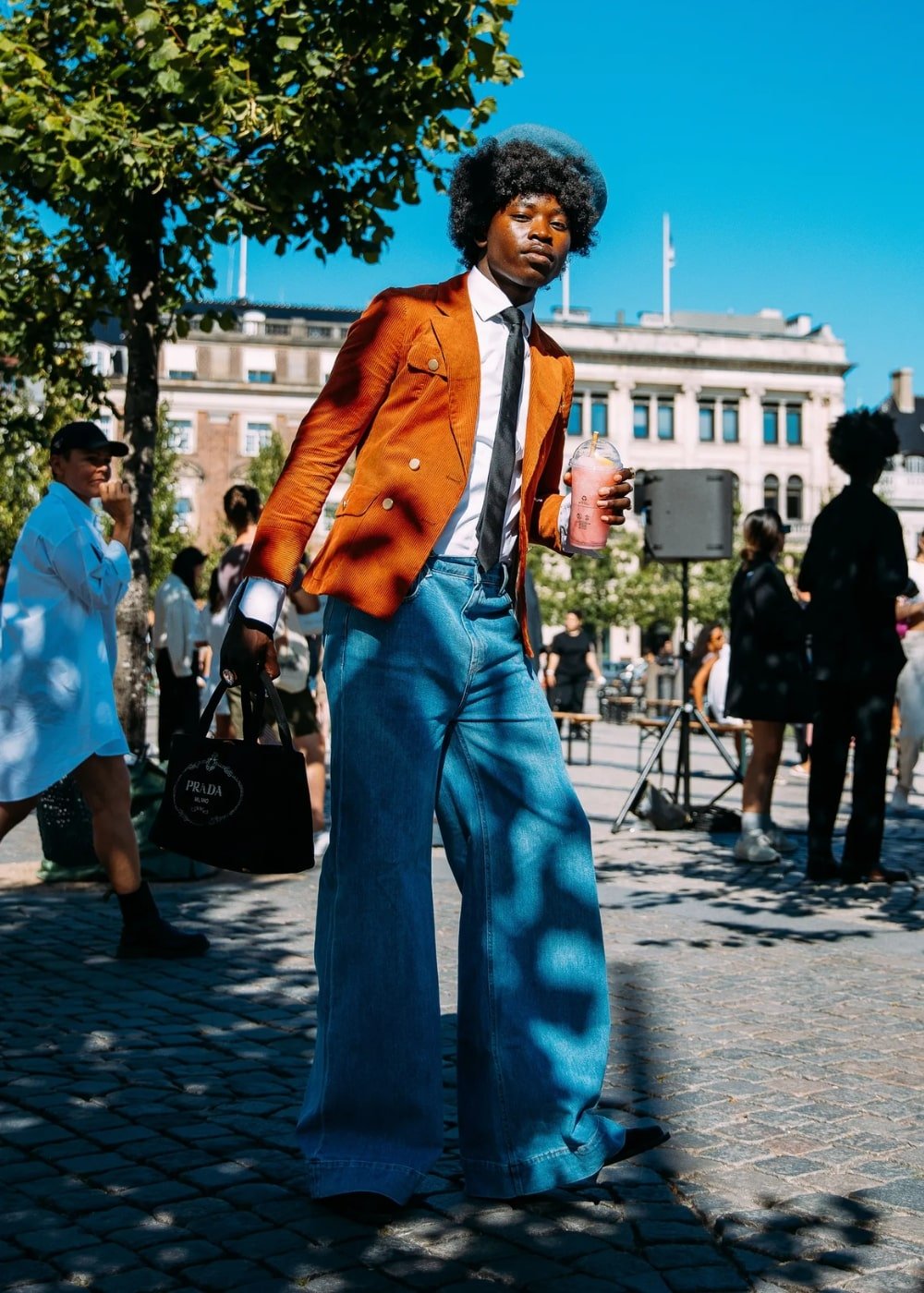 Street Style de Copenhagen - calça flare jeans, camisa branca, gravata e blazer laranja - street style - Primavera - homem em pé na rua usando uma boina azul - https://stealthelook.com.br