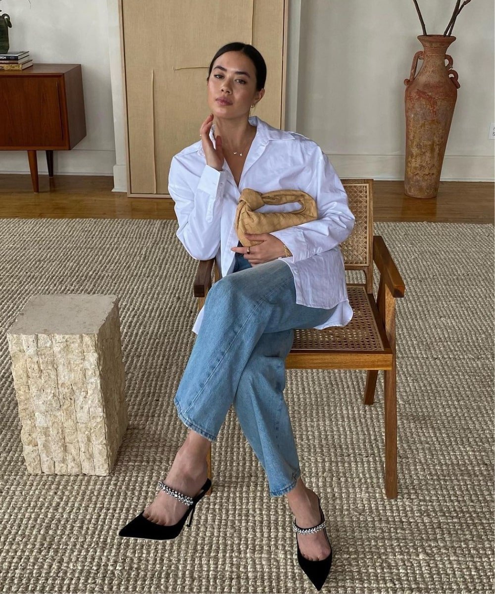 Sasha Mei - calça jeans, camisa branca e scarpin - looks com jeans - Outono - sentada em uma cadeira - https://stealthelook.com.br