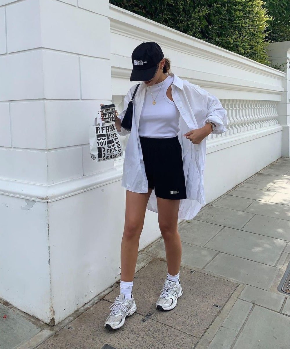 @missjamiefirth - short preto, regata, camisa branca, boné e tênis - looks com tênis esportivos - Verão - andando na rua - https://stealthelook.com.br