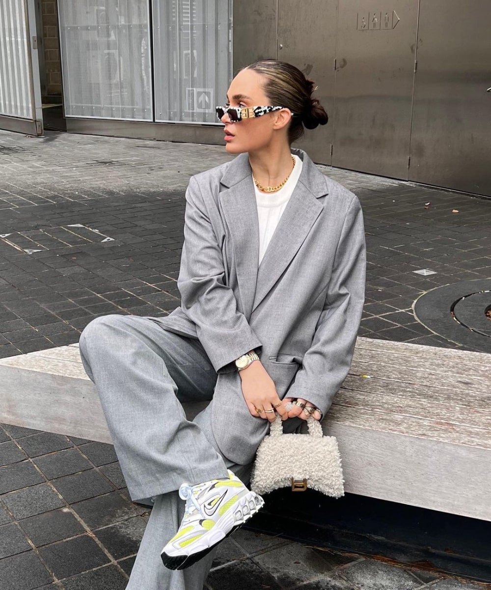 Alicia Roddy - terninho cinza, óculos e tênis - looks com tênis esportivos - Outono - sentada na rua - https://stealthelook.com.br