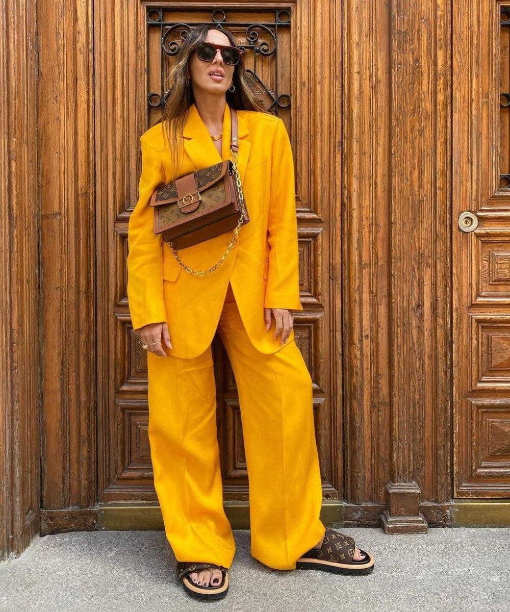 Laura Eguizabal - terninho amarelo, papete e bolsa monograma - looks de primavera - Primavera - em pé na rua usando óculos de sol - https://stealthelook.com.br