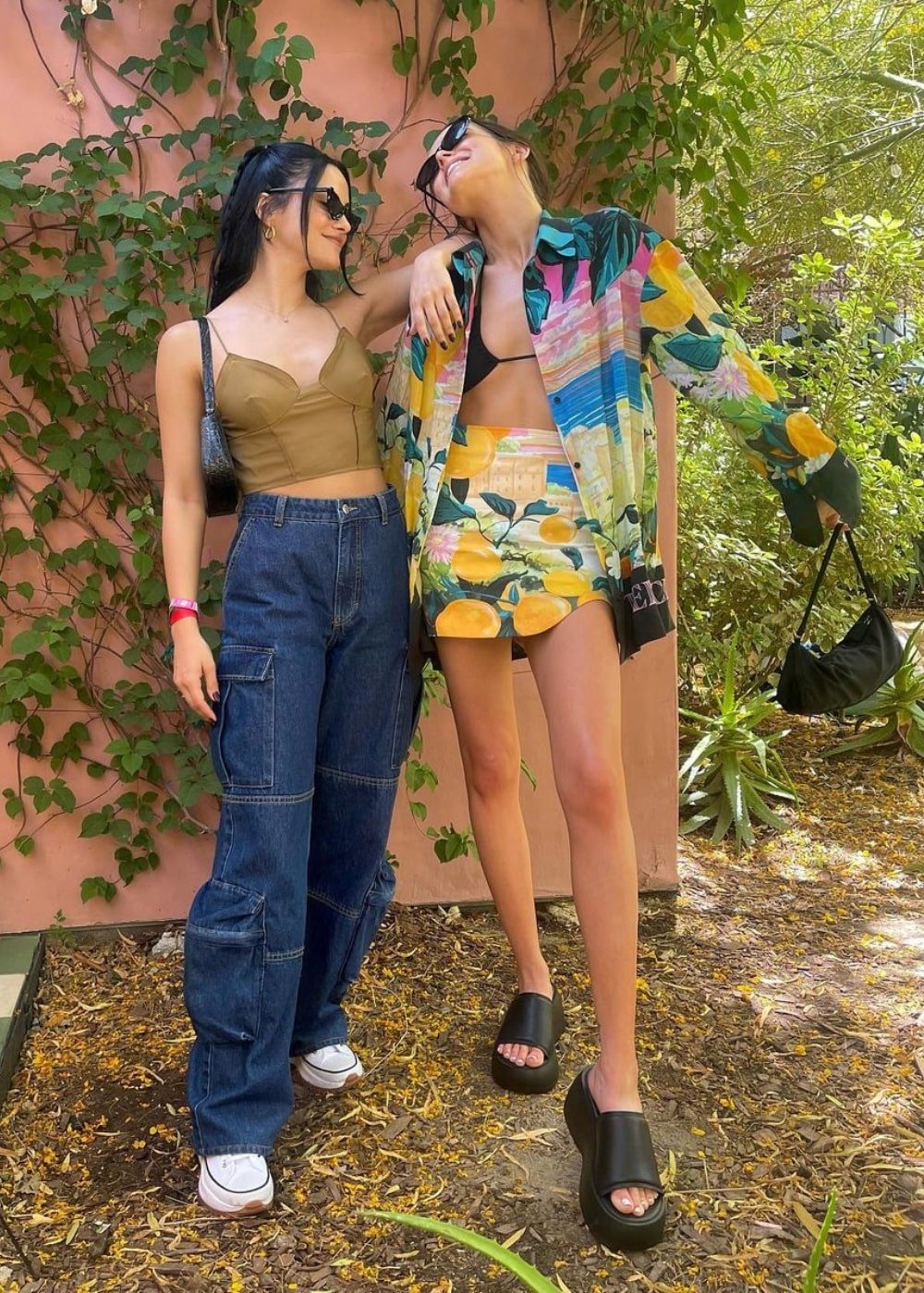 Camila Mendes - calça jogger jeans, croppe bege e tênis - Camila Mendes - Verão - em pé na rua abraçada com uma amiga - https://stealthelook.com.br