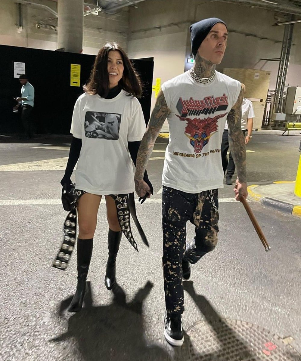 Kourtney Kardashian e Travis Barker - blusa preta de manga longa, sobreposição de t-shirt e botas - Kourtney Kardashian - Verão - andando na rua de mão dadas - https://stealthelook.com.br