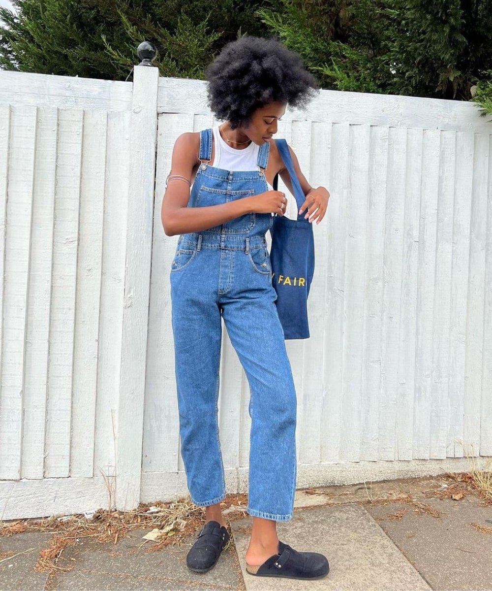 @georgia_3.0 - macacão jeans, clog e top branco - peças indispensáveis - Verão - em pé na rua mexendo na bolsa - https://stealthelook.com.br