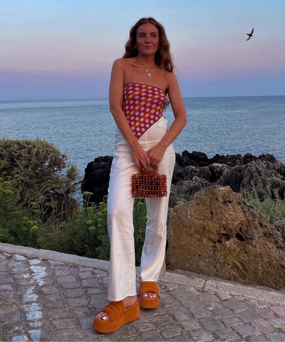 Rebecca Olivia | @rebeccaferrazwyatt - calça branca, top lenço colorido e plataforma laranja - looks de verão - Verão - em pé na rua - https://stealthelook.com.br