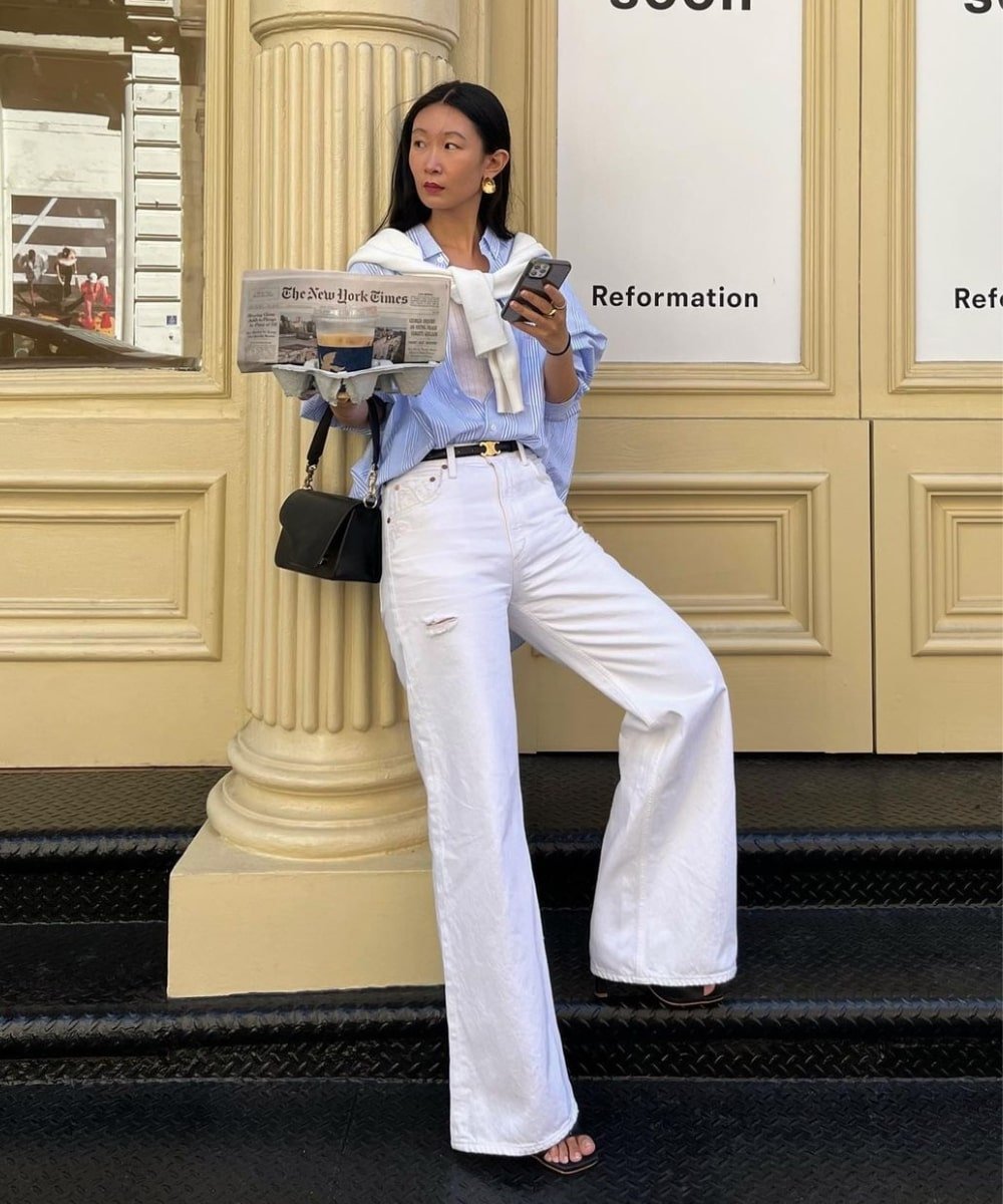Caroline Lin - calça preta, camisa azul social e salto alto - calças da moda 2023 - Outono - em pé na rua - https://stealthelook.com.br