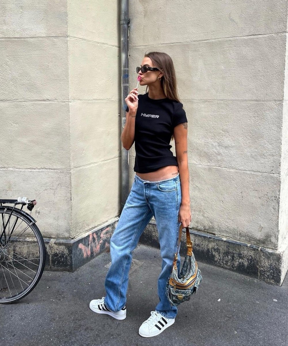 Anna Winck - calça jeans reta cintura baixa, tshirt preta e tenis - calças da moda 2023 - Primavera - em pé na rua - https://stealthelook.com.br