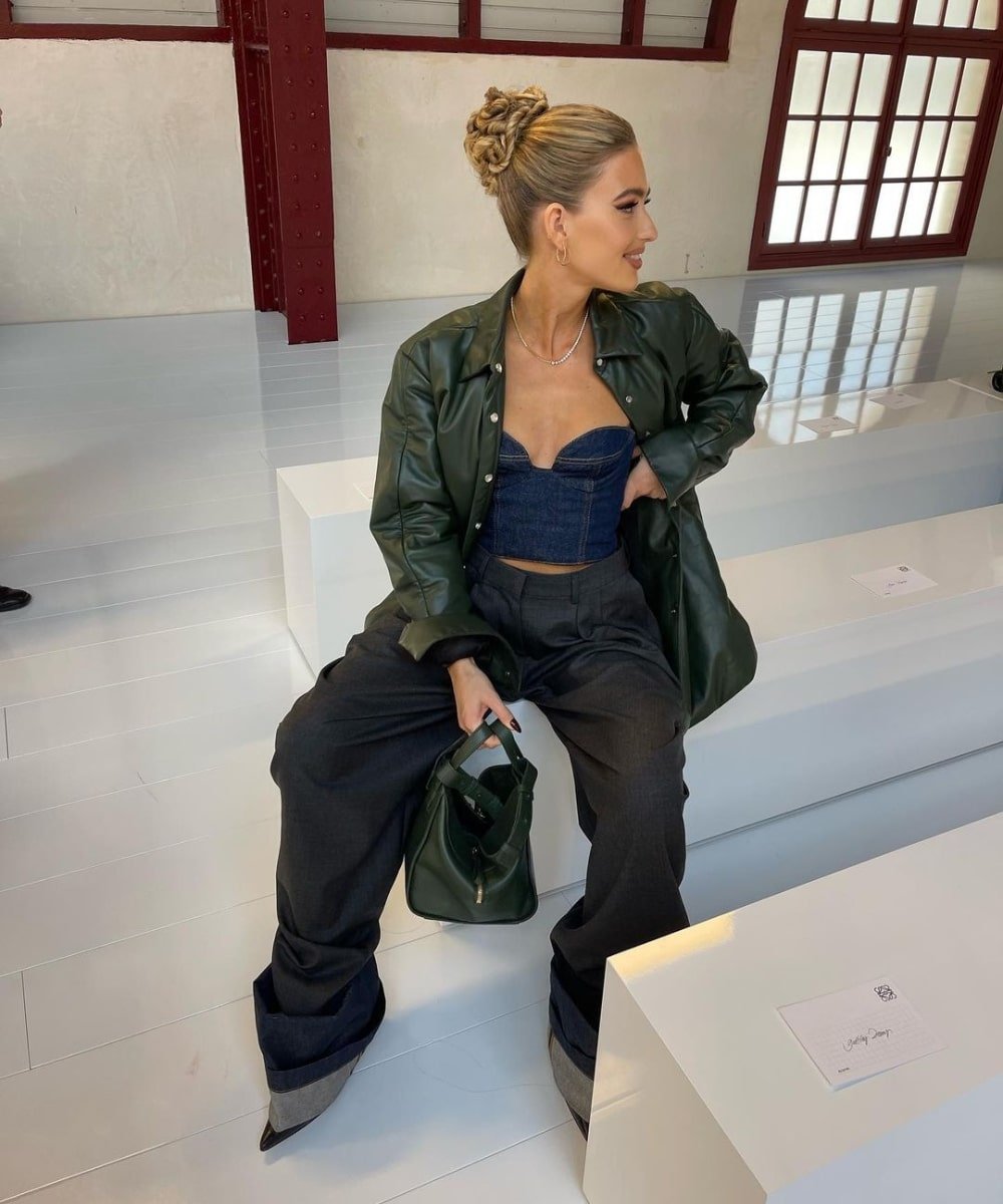 Emili Sindlev - calça baggy, corset jeans e jaqueta oversized - Paris Fashion Week - Outono - sentada e olhando para o lado - https://stealthelook.com.br