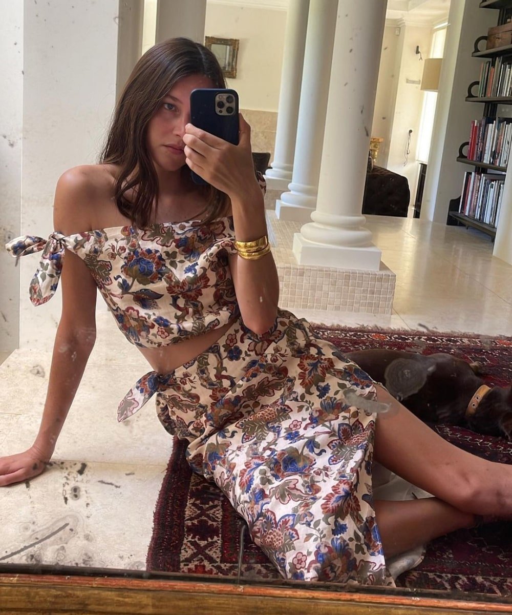 Sara Ramén - conjunto de cropped e saia midi florido e bracelete dourado - anos 80 - verão - sentada e tirando foto na frente do espelho - https://stealthelook.com.br