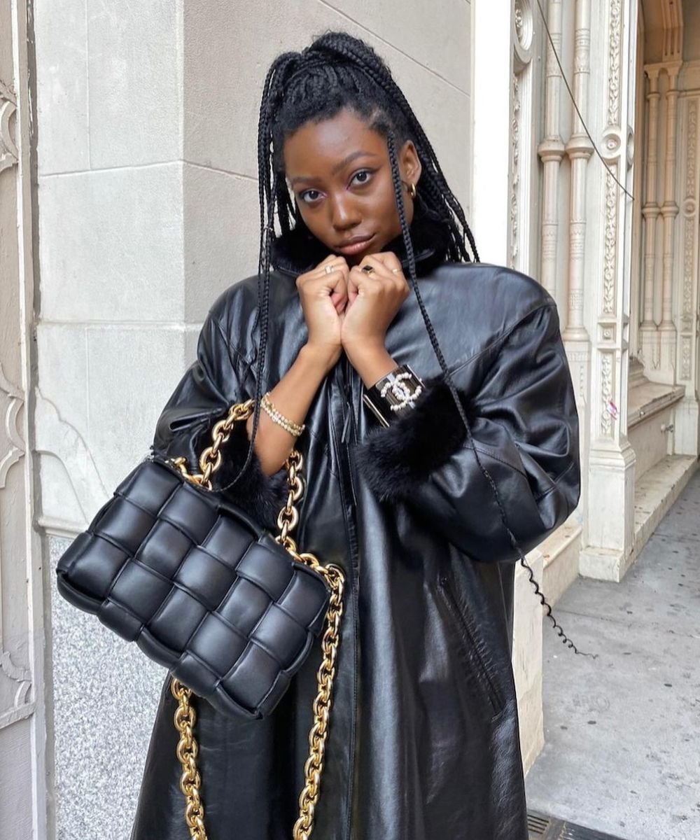 Chanel Mckinsie - casaco de couro preto, braceletes e minissaia preta - anos 80 - inverno - em pé na rua - https://stealthelook.com.br