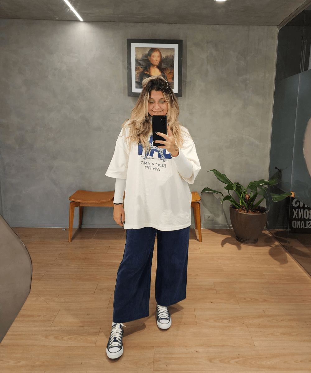 Leticia Moschion - calça ampla azul, t-shirt oversized e tênis - tênis All Star - outono - em pé tirando foto na frente do espelho - https://stealthelook.com.br